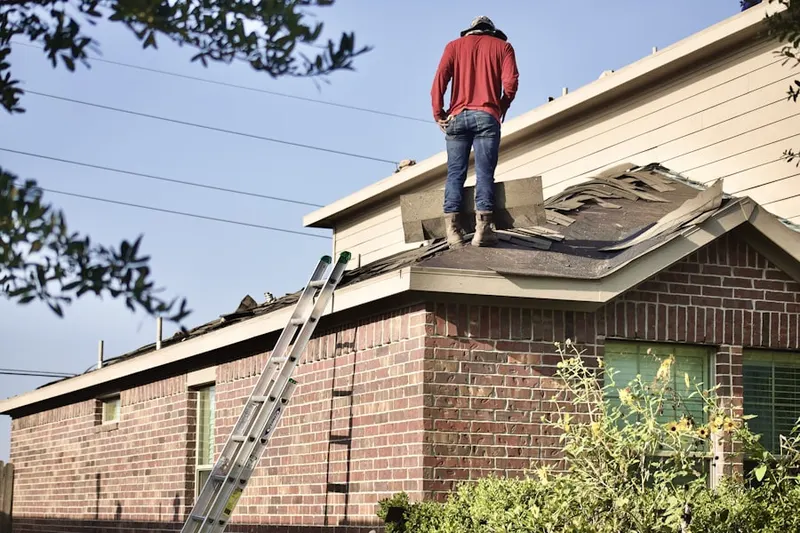 Professional roofer working on a residential roof in Regina Heights